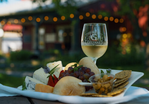 Vin blanc du Domaine Gélinas accompagné d'une assiette de fromages et de fruits.