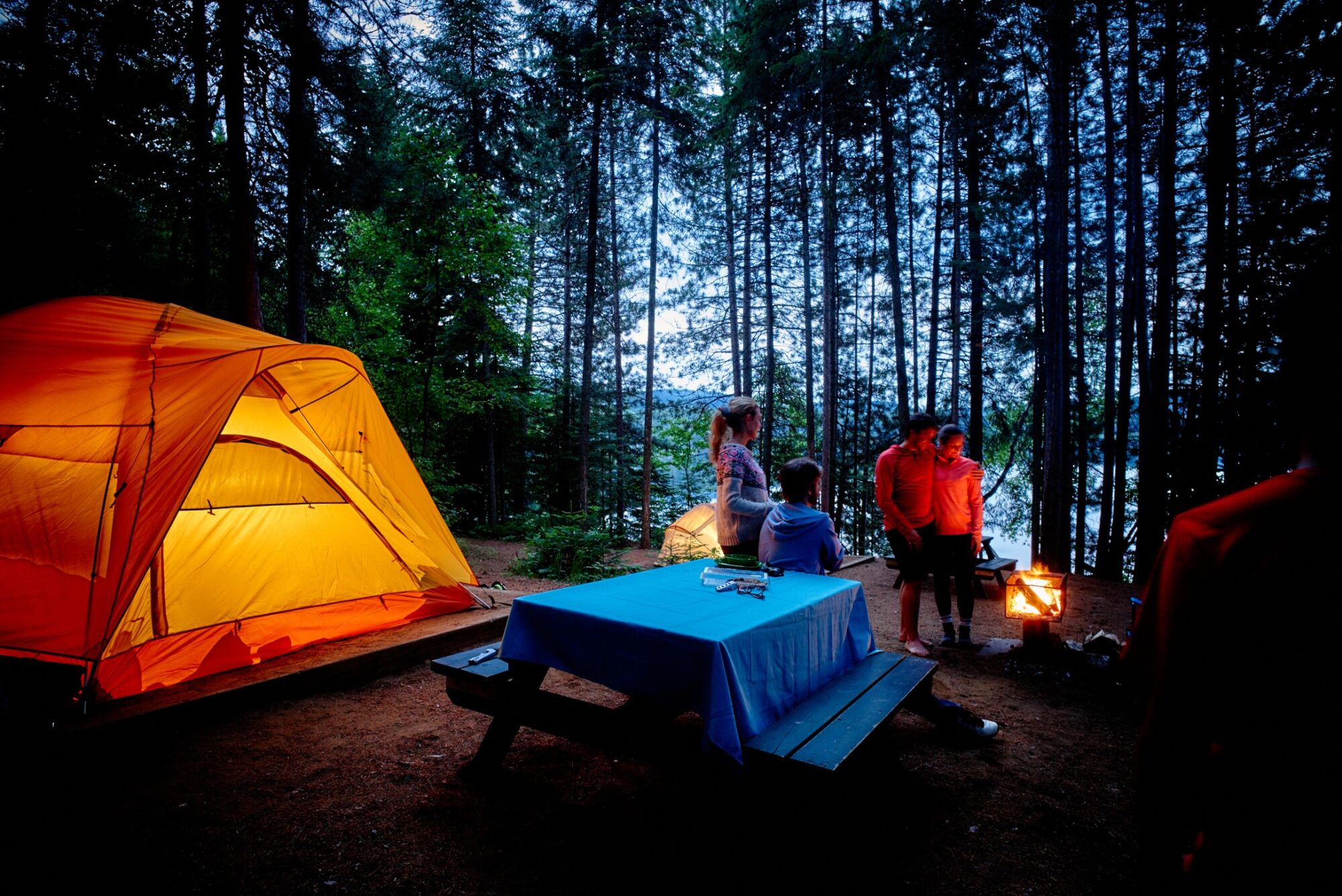 Famille en camping près d'un feu de camp et leur tente au parc national de la Mauricie
