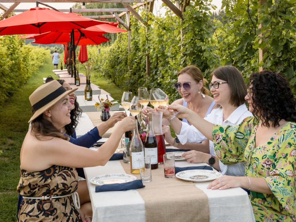 Groupe de femmes dégustant du vin à une table au milieu des vignes au Vignoble et Domaine Beauchemin