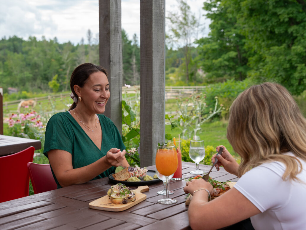 Deux femmes qui dînent sur la terrasse de l'Éco-café au Baluchon Éco-villégiature