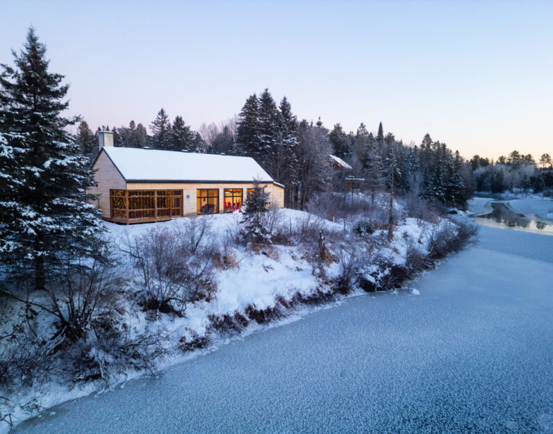 Chalet enneigé le Payageur sur le bord d'une rivière au Baluchon