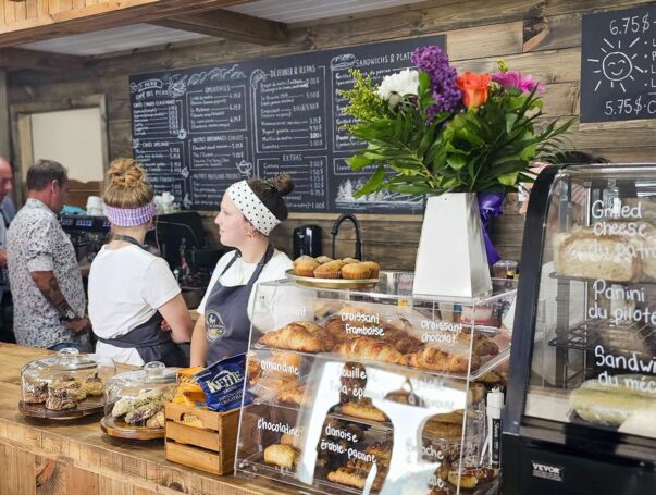 Comptoir du Café des Pilotes avec les employés, le menu et un présentoir de patisseries