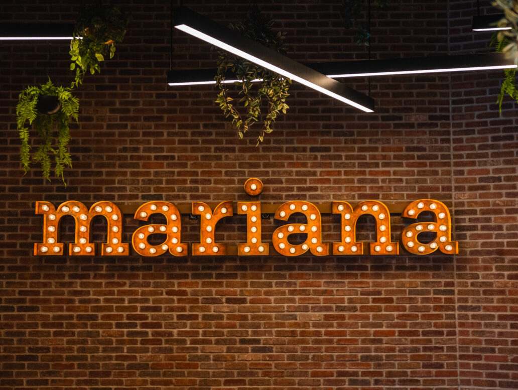 Enseigne lumineuse de Mariana sur le mur de brique à l'intérieur du restaurant