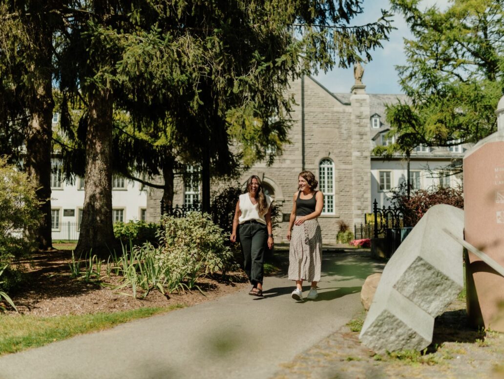 Deux femmes qui marchent dans le parc devant le Musée des Ursulines